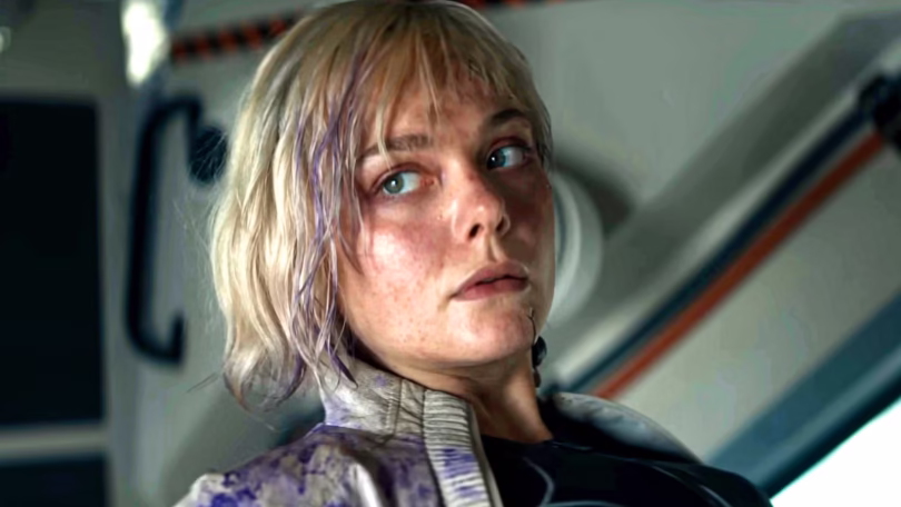 elle fanning s thia looking seriously off to the right while seated in a ship in predator badlands.j